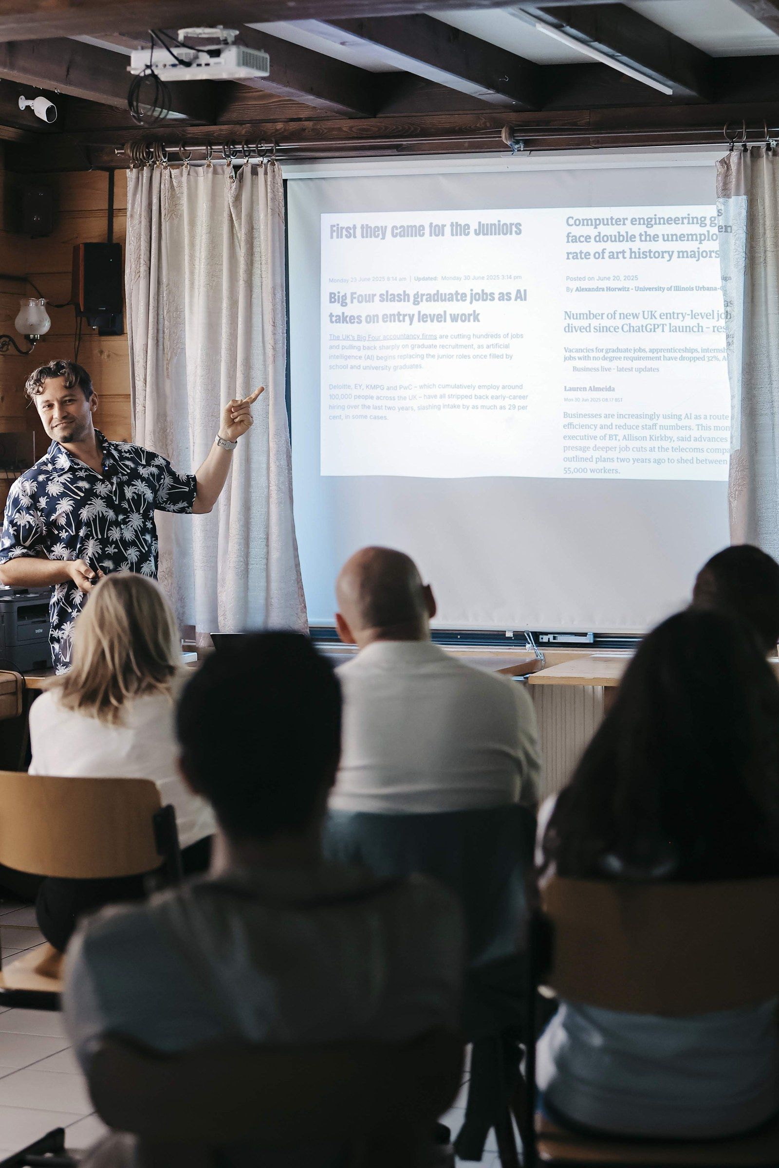 Daniel Duma pointing at a slide titled “First they came for the juniors” at Swiss Nomad Fest
